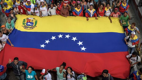 Partidarios del presidente venezolano, Nicolás Maduro con la bandera nacional - Sputnik Mundo
