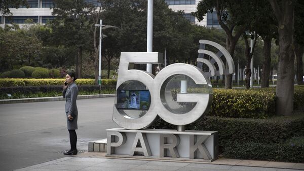 Una empleada de Huawei habla por teléfono cerca de un monumento a la tecnología 5G - Sputnik Mundo