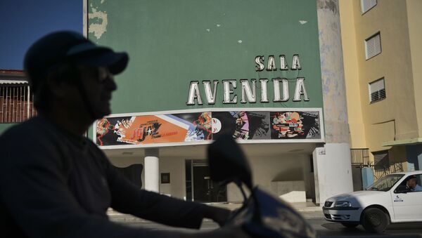 Un motociclista pasa por la Avenida Cínema en la Habana - Sputnik Mundo
