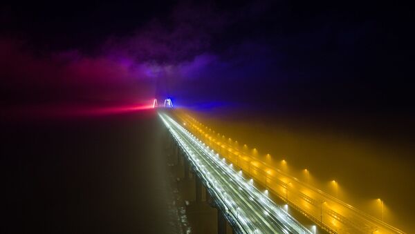 El puente de Crimea iluminado con luces coloridas durante la noche - Sputnik Mundo