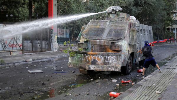 Un carro lanzaguas durante una protestas en Santiago, Chile - Sputnik Mundo