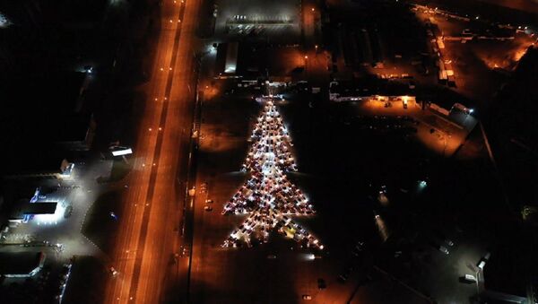 Cientos de autos forman un gigante árbol de Navidad iluminado - Sputnik Mundo