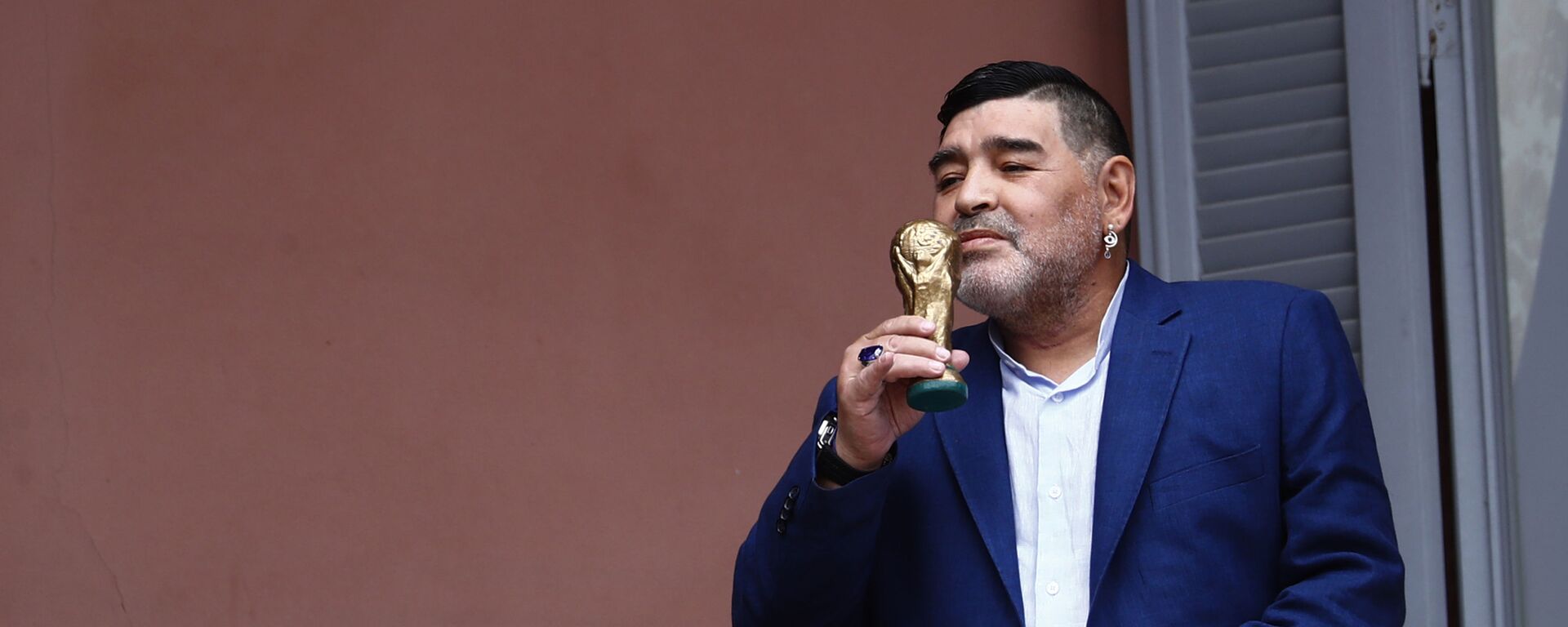 El exfutbolista Diego Armando Maradona besa una réplica de la Copa del Mundo en el balcón de la Casa Rosada - Sputnik Mundo, 1920, 27.10.2021