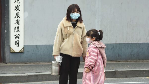 Una mujer y una niña usando máscaras para no contagiarse en China - Sputnik Mundo