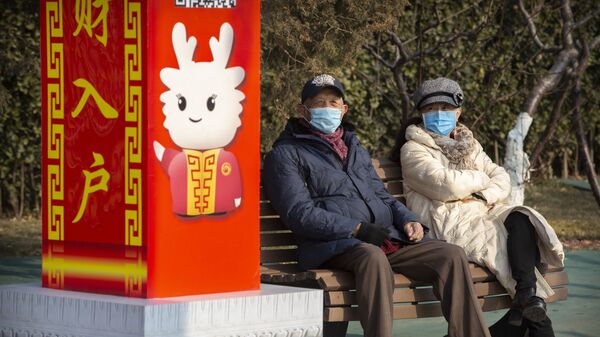 Personas con mascarillas en un parque de Pekín, China - Sputnik Mundo