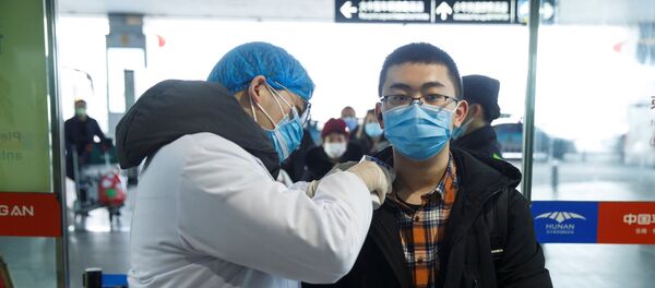 Un chino durante la revisión para detectar el coronavirus Un chino durante la revisión para detectar el coronavirus - Sputnik Mundo
