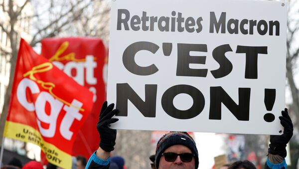 Un manifestante sostiene una pancarta que dice No a la reforma de las pensiones de Macron  - Sputnik Mundo