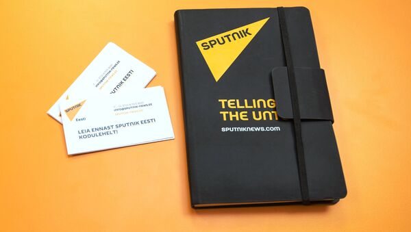 Un cuaderno con logo de Sputnik y tarjetas de visita de Sputnik Estonia - Sputnik Mundo