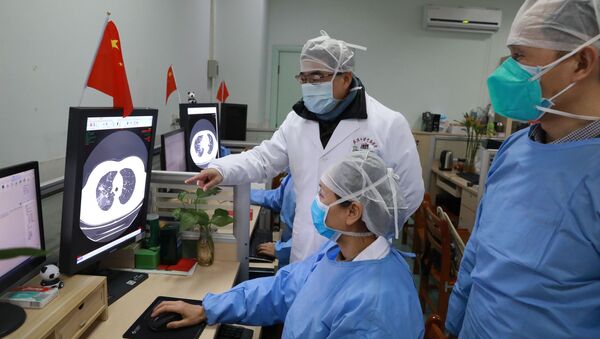 Médicos del hospital de Zhongnan en Wuhan observando la tomografía de un paciente  - Sputnik Mundo