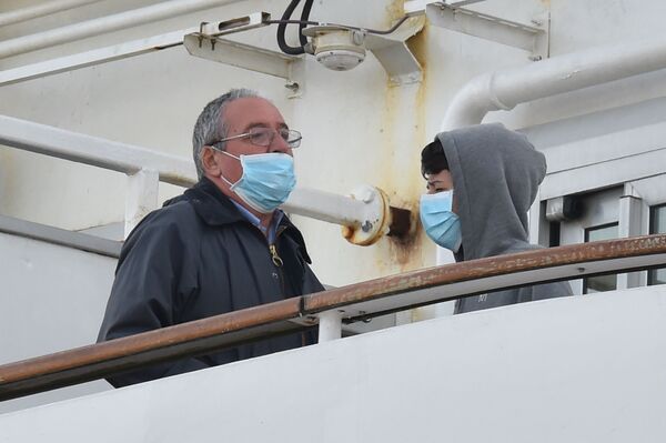 Пассажиры в медицинских масках на борту круизного лайнера Diamond Princes, помещенного в карантин у японского порта Йокогама - Sputnik Mundo