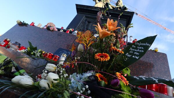 Velas y flores colocadas alrededor del monumento a los hermanos Grimm en honor a las víctimas del tiroteo en Hanau - Sputnik Mundo