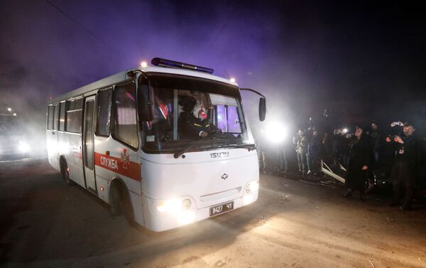Los autobuses que transportan a los evacuados de China pasan por delante de los manifestantes durante una protesta contra su llegada - Sputnik Mundo