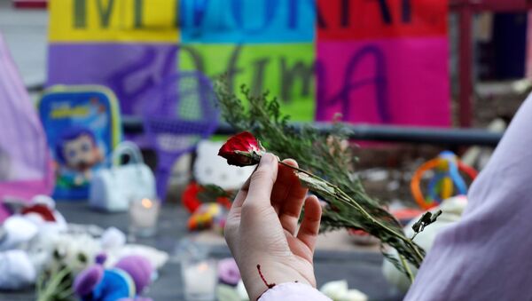 Una persona con una flor en homenaje a la niña asesinada - Sputnik Mundo