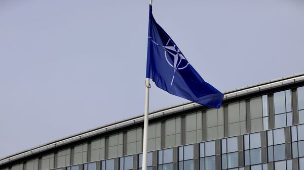 La bandera de la OTAN y de algunos de sus miembros ondean frente a la sede de la organización en Bruselas - Sputnik Mundo