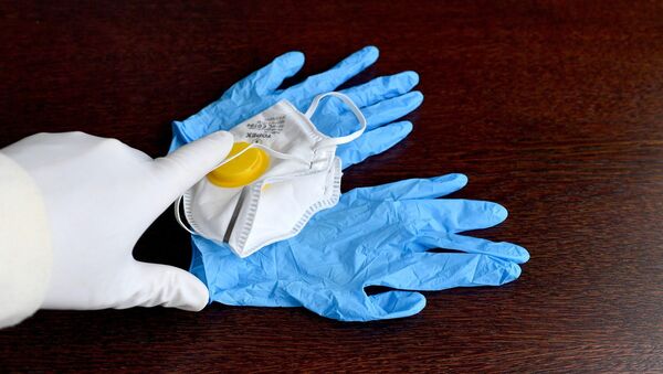Una mascarilla y unos guantes para protegerse del coronavirus - Sputnik Mundo