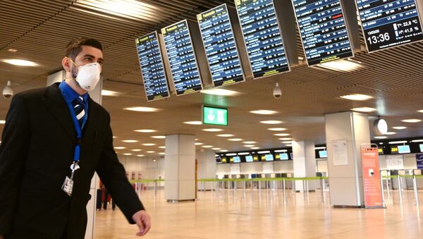 Un hombre en mascarilla en el aeropuerto de Barajas, Madrid - Sputnik Mundo