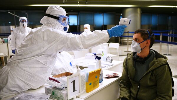 Un médico toma la temperatura a un pasajero en un aeropuerto de Rusia - Sputnik Mundo