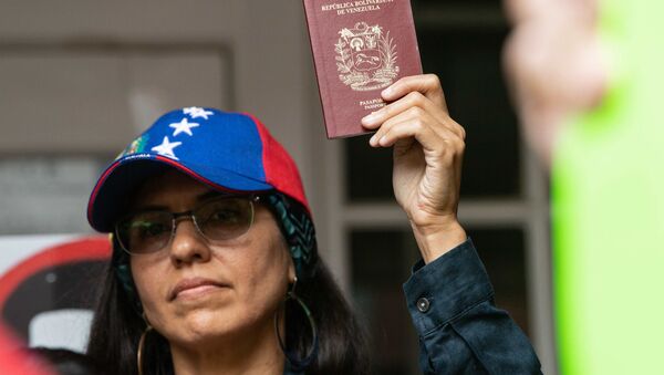 Una mujer sostiene en sus manos un pasaporte venezolano - Sputnik Mundo