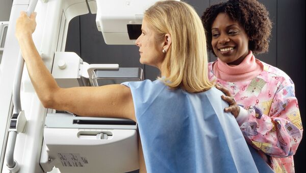Una médica acompaña una mujer durante una mamografía - Sputnik Mundo