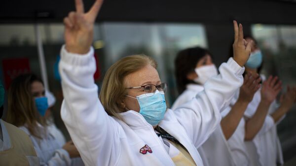 Trabajadora médica hace una señal de victoria en un gesto en apoyo al personal que está trabajando para vencer el brote del coronavirus SARS-CoV-2 en el hospital Puerta de Hierro en Majadahonda (España) - Sputnik Mundo