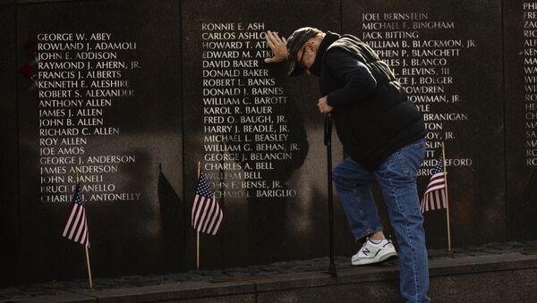 Un veterano de guerra se lamenta ante el memorial a los caídos en la Guerra de Vietnam en Philadelphia, EEUU - Sputnik Mundo