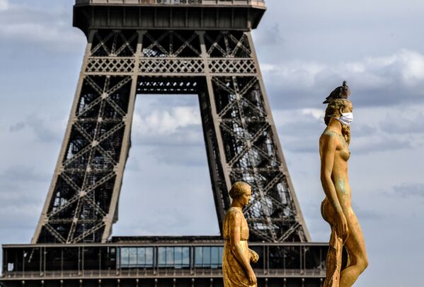 La Torre Eiffel se ve detrás de las estatuas de bronce con mascarillas, en el Parvis des Droits de l'Homme, en Francia - Sputnik Mundo
