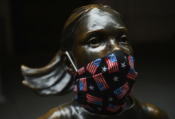La famosa estatua 'Fearless Girl', que está en Wall Street, lleva una máscarilla con pequeñas banderas estadounidenses  - Sputnik Mundo