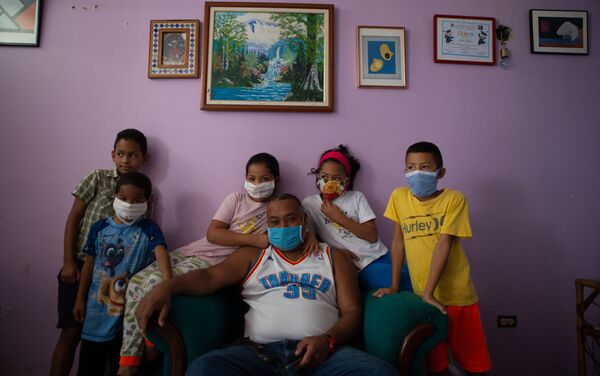 Un grupo de niños posan junto a su padre para un retrato en un departamento en La Lira, un vecindario en el área de Petare. Caracas, Venezuela.   - Sputnik Mundo