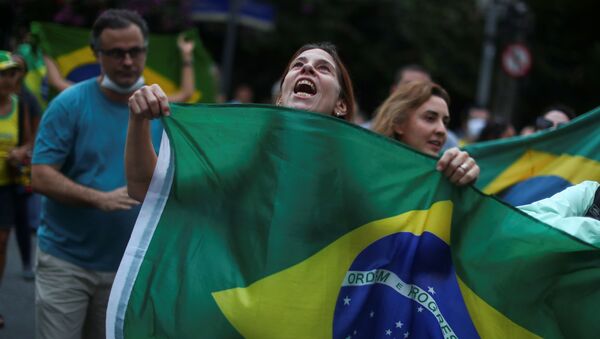 Una mujer sostiene la bandera de Brasil en una manifestación en Río de Janeiro - Sputnik Mundo