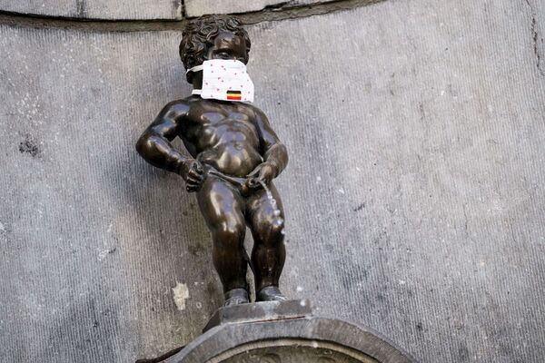 La famosa estatua de bronce del Manneken Pis, en Bruselas, con una mascarilla. - Sputnik Mundo