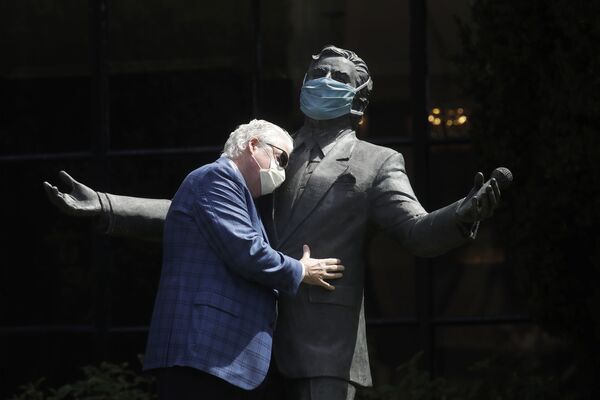 Paul Tormey, vicepresidente de Fairmont Hotels, abraza la estatua del cantante Tony Bennett en el Hotel Fairmont San Francisco de la ciudad del mismo nombre, en EEUU.   - Sputnik Mundo