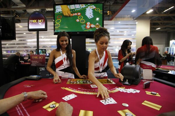 Attendants conduct play with the visitors over a Black Jack gaming table during the Global Gaming Expo Asia in Macau - Sputnik Mundo