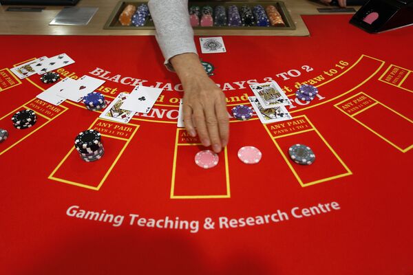 A gambling school student practices on a table in Macau, China - Sputnik Mundo