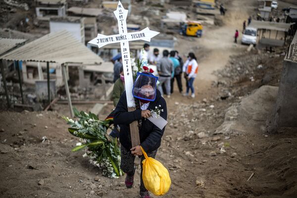 Родственник жертвы коронавируса несет крест по кладбищу на окраине Лимы, Перу - Sputnik Mundo