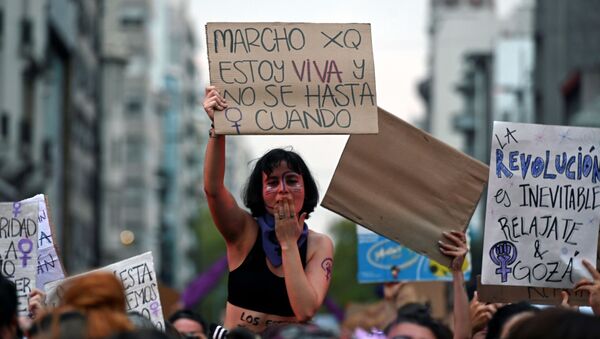 Mujer sostiene un cartel contra los feminicidios durante la marcha del 8 de marzo de 2020 en Montevideo - Sputnik Mundo