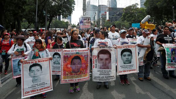 Los parientes sostienen carteles con fotos de estudiantes desaparecidos en una manifestación en México - Sputnik Mundo