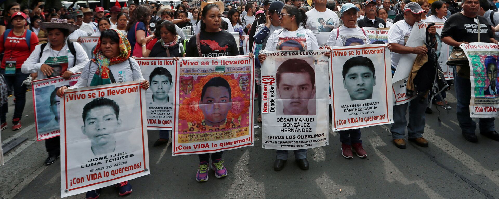 Los parientes sostienen carteles con fotos de estudiantes desaparecidos en una manifestación en México - Sputnik Mundo, 1920, 20.09.2021