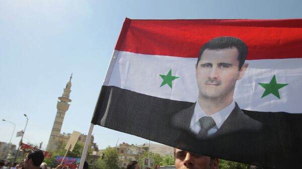 Bandera siria con imagen de Bashar al-Asad (archivo) - Sputnik Mundo