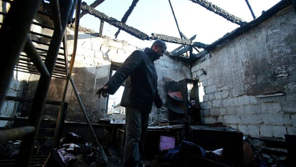 Hombre en su casa dustruida en Donetsk - Sputnik Mundo